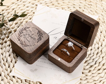 May include: Two wooden ring boxes. One box is closed and has the inscription "Salome 08.15.2021" engraved on the top. The other box is open and shows a velvet interior with two rings inside.