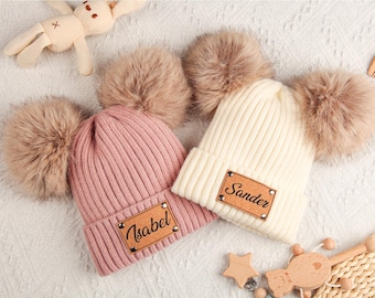 Può includere: Due berretti in maglia con pompon in finta pelliccia. Uno è rosa con "Isabel" su un'etichetta in pelle, l'altro è color crema con "Sander". Accessori: peluche e giocattoli in legno.