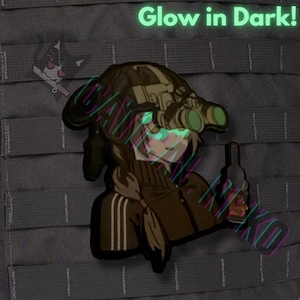 May include: A black and brown patch with an anime-style character wearing night vision goggles and holding a bottle. The text "Glow in Dark!" is at the top. The character's eyes and face glow green.