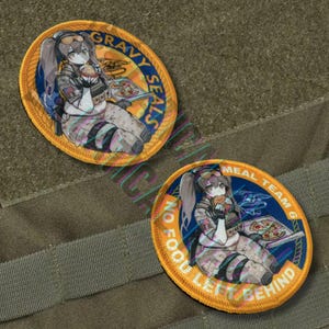 May include: Two circular embroidered patches featuring an anime-style character eating a burger and pizza. The patches have text that reads "Gravy Seals" and "Meal Team 6, No Food Left Behind". The patches have a yellow border and blue accents.
