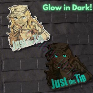 May include: A glow-in-the-dark patch featuring an anime-style illustration of a woman in a military-style cap and uniform. The text "Just the Tip" is below the image. The patch glows green in the dark.