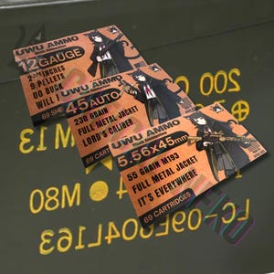 May include: Three rectangular boxes with anime-style illustrations and text. The boxes are labeled "UWU AMMO" and list ammunition specifications, including "12 GAUGE," "45 AUTO," and "5.56x45mm." The background is a green surface with yellow text.