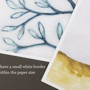 May include: Two watercolor paintings, one with a blue branch with green leaves and the other with a yellow and brown landscape. The text "Prints have a small white border within the paper size" is at the bottom of the image.
