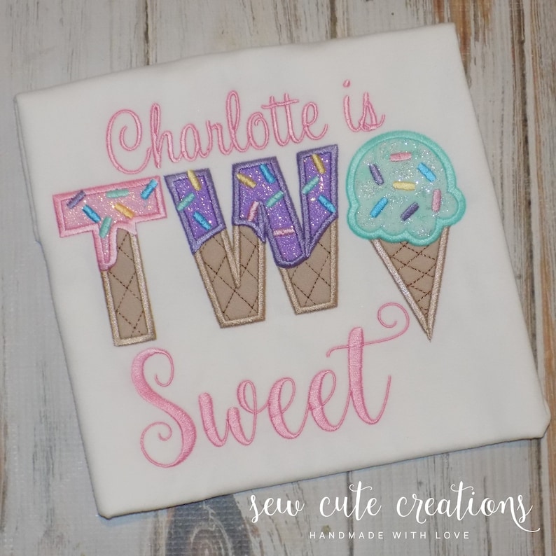 May include: A white t-shirt with pink embroidery that says "Charlotte is TWO Sweet" with the number two made to look like ice cream cones with sprinkles and melted chocolate.