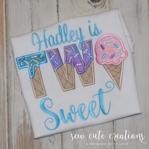 May include: A white t-shirt with blue embroidery that says "Hadley is Two Sweet" with ice cream cone graphics. The ice cream cones are purple, pink, and blue with sprinkles.