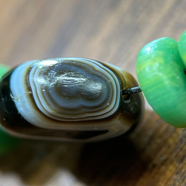 Ancient natural oval-shaped sardonyx beads from the Achaemenid Empire period, paired with Qing Dynasty green-colored glaza beads