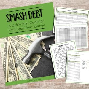 Op de afbeelding: Een groen en wit boek getiteld "Smash Debt: A Quick-Start Guide for Your Debt-Free Journey" door Stephanie Jones. De omslag van het boek toont een hamer die op een stapel Amerikaanse dollarbiljetten slaat.