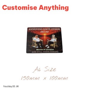 May include: A rectangular sign measuring 150mm x 100mm featuring an illustration of two people sitting in chairs by a lake at sunset. The text reads ANNOYING EACH OTHER SINCE 1992, Martin & Lorraine, AND STILL GOING STRONG. The sign is A6 size.