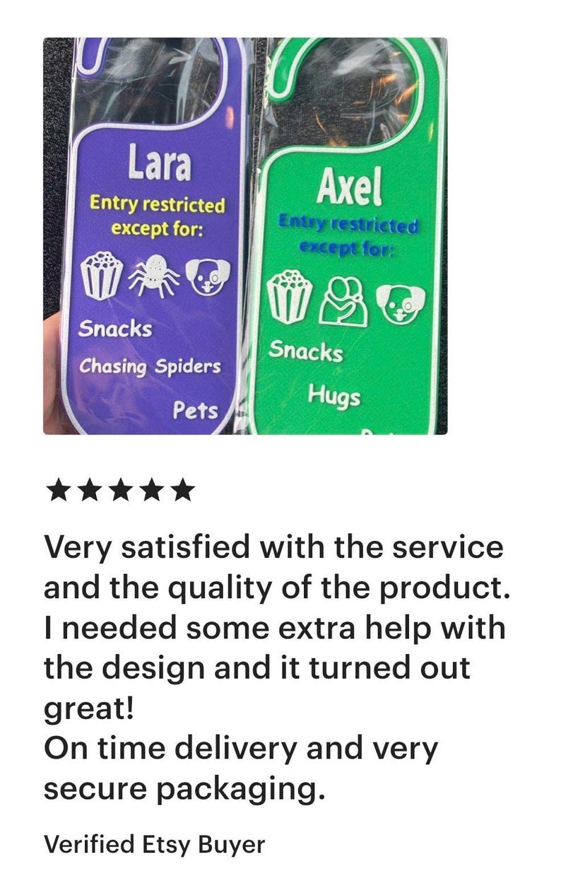 K&ouml;nnte beinhalten: Zwei T&uuml;rschilder, eines in Lila und eines in Gr&uuml;n, mit wei&szlig;em Text und Symbolen. Das lila Schild sagt "Lara" und listet "Snacks, Spinnen jagen, Haustiere". Das gr&uuml;ne Schild sagt "Axel" und listet "Snacks, Umarmungen".