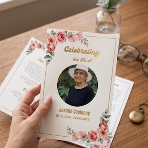 May include: A funeral program card featuring a circular portrait of an older person wearing a white hat and black shirt. The card has gold text reading Celebrating the life of Jasmin Cooleney 12.02.1950-12.06.2026, framed by watercolor pink roses.