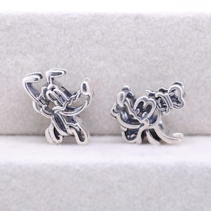 May include: Two silver-colored Mickey Mouse charm beads. Each charm features a stylized Mickey Mouse design with his iconic ears and a bow. The charms are detailed and appear to be made of a shiny metal.