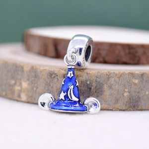 May include: A silver charm with a blue wizard hat design. The hat features a crescent moon and stars, with silver accents. The charm has a polished finish and is likely made of sterling silver.