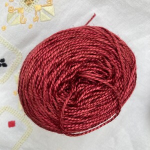 May include: A ball of deep red yarn, wound tightly, ready for knitting or crocheting.