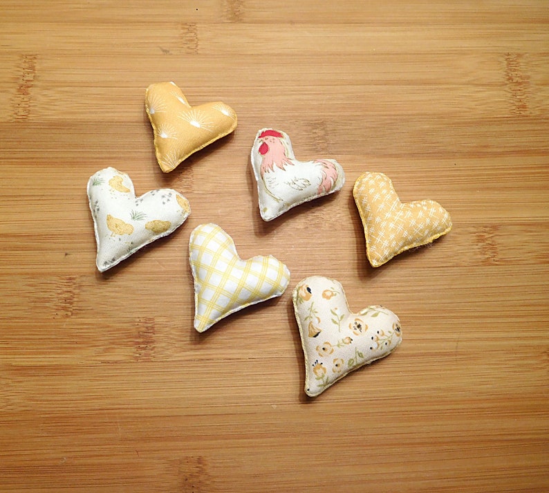 Six hearts that are 2 and 1/4th inches in this set.
Great gift for a Rooster lover.
  In shades of beige, white, red and tan these have a Rooster, chickens, chicken scratches, sunrises and baby chicks on them.