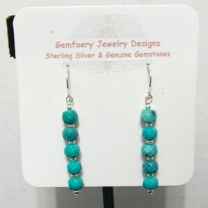 May include: Turquoise dangle earrings with sterling silver hooks. Each earring features six turquoise beads in a graduated size.