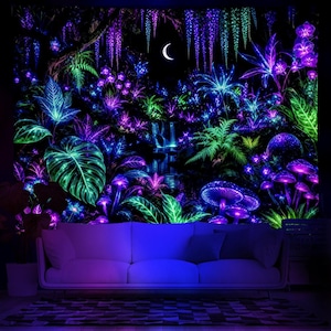 Könnte beinhalten: Ein Schwarzlicht-Wandteppich mit einer leuchtenden Waldszene. Das Design zeigt üppiges Laub in Grün-, Blau- und Lilatönen, mit Pilzen, einem Wasserfall und einem Halbmond. Der Wandteppich wird über einem weißen Sofa präsentiert.