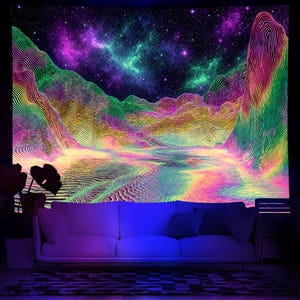 May include: A vibrant tapestry featuring a psychedelic landscape with mountains, a lake, and a starry night sky. The artwork uses a spectrum of colors, including green, purple, yellow, and pink, creating a surreal and otherworldly scene. A white sofa is in front of the tapestry.