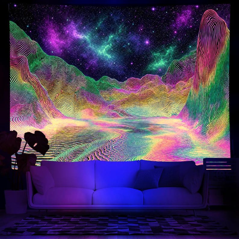 May include: A vibrant tapestry featuring a psychedelic landscape with mountains, a lake, and a starry night sky. The artwork uses a spectrum of colors, including green, purple, yellow, and pink, creating a surreal and otherworldly scene. A white sofa is in front of the tapestry.