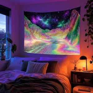 May include: A vibrant tapestry depicting a colorful, abstract landscape with mountains, a river, and a starry night sky. The artwork features a spectrum of colors, including pink, green, yellow, and purple, creating a psychedelic effect. The tapestry is hanging above a bed.