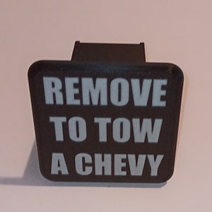 May include: Black plastic hitch cover with the text "REMOVE TO TOW A CHEVY" in white letters.