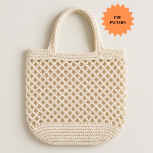 Può includere: Borsa tote all'uncinetto color crema con un design a rete a forma di diamante. La borsa ha un fondo arrotondato e due manici. Il testo "PDF PATTERN" è in una forma a stella arancione in alto a destra.