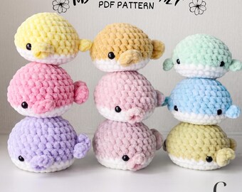 May include: A collection of handmade crochet whale toys in various pastel colors, including yellow, pink, purple, and blue. Each whale has a white belly, small black eyes, and side fins. The text "MY CUTE CROCHET PDF PATTERN" is displayed at the top.