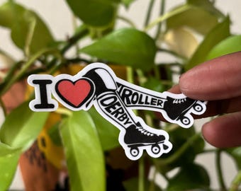 May include: A sticker with the words "I ❤️ ROLLER DERBY". The sticker features a red heart and black roller skates. The text is in black and white.