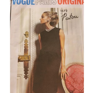 May include: A vintage Vogue Paris Original sewing pattern featuring a woman in a black dress. The pattern is labeled "1572 by Patou." The image has the text "Vogue Paris Originals" at the top.