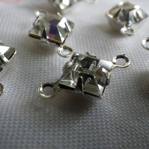 May include: Silver-toned metal clasps with clear crystal accents. Each clasp has two loops for attaching jewelry or other items.