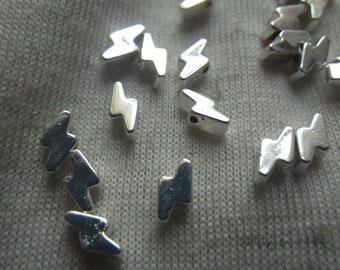 Perline di ematite sintetica argentata a forma di fulmine, 6 x 3 mm, 25 pezzi