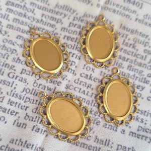 May include: Four gold-toned oval-shaped metal frames with scalloped edges. The frames are blank and ready for crafting projects.