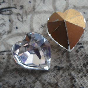 May include: Two heart-shaped embellishments, one clear glass and one gold foil.