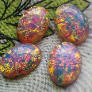 May include: Four oval-shaped iridescent glass cabochons with a crackled, marbled effect in shades of pink, orange, yellow, and green.