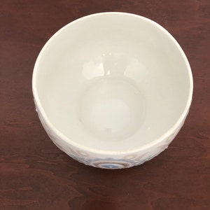 May include: White ceramic bowl with a blue and white floral design. The bowl is empty and has a smooth, glossy finish.