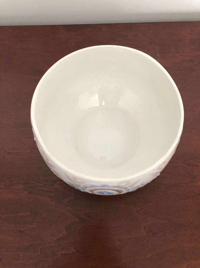 May include: White ceramic bowl with a blue and white floral design. The bowl is empty and has a smooth, glossy finish.