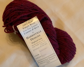 May include: A skein of burgundy wool yarn labeled "Harrisville Designs Highland Style" with details like needle size, gauge, and yardage. The label also includes the color "Burgundy" and dye lot number 4760.