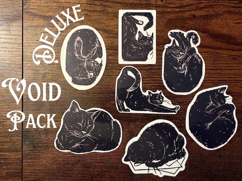 Puede incluir: Una colecci&oacute;n de siete pegatinas de gatos en blanco y negro con varias posturas felinas, incluyendo posiciones durmiendo, estir&aacute;ndose y acurrucadas. El texto DELUXE VOID PACK est&aacute; impreso en blanco en el lado izquierdo de la disposici&oacute;n de pegatinas.