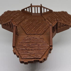 Puede incluir: Una plataforma de madera marrón de tres secciones con barandillas. La plataforma está diseñada para juegos de mesa.