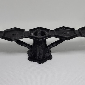 May include: A black 3D printed tree stand with five hexagonal platforms. The stand is designed to hold small objects or figurines.