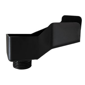 Puede incluir: Un accesorio de plomería negro y angular con una base roscada. El accesorio tiene una cuenca rectangular y una superficie plana inclinada. El diseño es elegante y moderno, con un acabado mate.