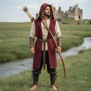 May include: A medieval-style outfit featuring a hooded burgundy vest, a cream-colored shirt, and dark brown pants. The ensemble includes a brown leather belt, arm guards, and a bow and arrow. A castle is visible in the background.