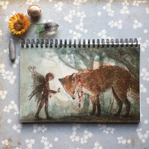 May include: A watercolor painting of a fairy with wings and a fox. The fairy is wearing a brown dress and has brown hair. The fox is brown and has a red and green necklace. The background is a light blue and green watercolor wash.