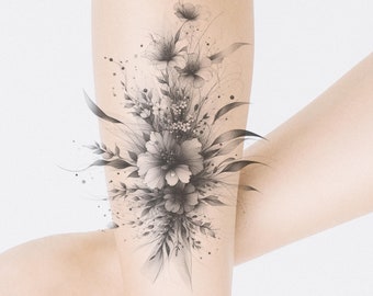 May include: A black and white floral tattoo design on a person's arm. The design features a bouquet of flowers with delicate leaves and stems.