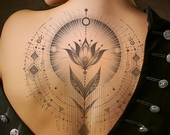 May include: A black and white geometric tattoo design featuring a stylized lotus flower with intricate details. The design is surrounded by a circle of geometric shapes and lines.