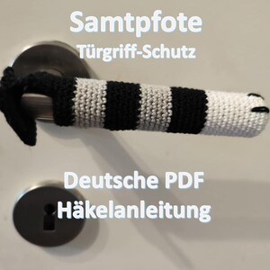 Può includere: Una copertura per maniglia della porta all'uncinetto a righe bianche e nere, con un design a forma di zampa all'estremità. Il testo sull'immagine recita "Samtpfote Türgriff-Schutz" e "Deutsche PDF Häkelanleitung".