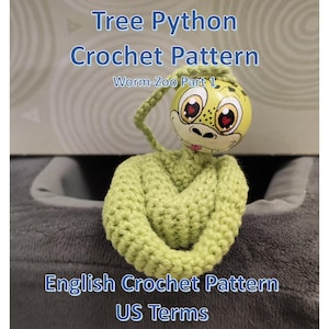 Könnte beinhalten: Ein gehäkeltes Baumpython-Spielzeug mit einem bemalten Holzkopf. Der Kopf ist gelb mit einem grünen Muster, großen Augen und einem lächelnden Gesicht. Der Körper ist hellgrün und gehäkelt. Der Text auf dem Bild lautet "Tree Python Crochet Pattern" und "English Crochet Pattern US Terms."