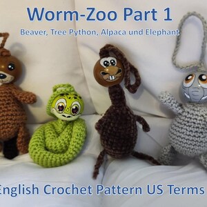 Op de afbeelding: Vier handgemaakte gehaakte dieren: een bruine bever, een groene boompython, een bruine alpaca en een grijze olifant. De dieren hebben houten hoofden met geschilderde details. De tekst "Worm-Zoo Part 1" en "English Crochet Pattern US Terms" zijn zichtbaar.
