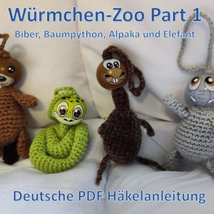 Op de afbeelding: Vier handgemaakte gehaakte dierenspeeltjes: een bruine beer, een groene slang, een bruin konijn en een grijze olifant. De speeltjes hebben houten hoofden met geschilderde gezichten. Boven staat "Würmchen-Zoo Part 1". Daaronder "Deutsche PDF Häkelanleitung".