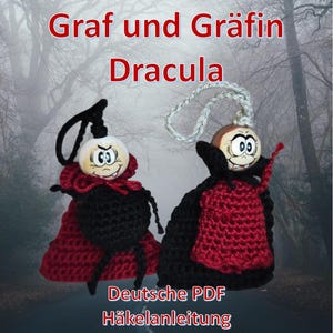 May include: Two handmade Dracula-themed ornaments. Each has a painted wooden head, a black crocheted body, and a red cape. The text "Graf und Gräfin Dracula" and "Deutsche PDF Häkelanleitung" are visible.