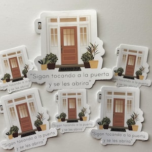 May include: Set of six stickers featuring a white house with a brown door and potted plants. Each sticker has a different variation of the text "Sigan tocando a la puerta y se les abrira" (Keep knocking and the door will be opened to you) and the reference "Mateo 7:7".